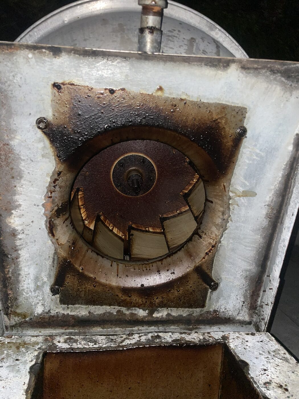 A grease-caked rooftop exhaust fan before cleaning